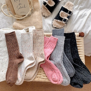 Close-up of thick knitted wool socks with colorful flecks in various warm earth tones