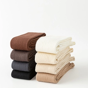 Detailed view of knitted vertical ribbed textures on knee-high socks in various earth tones