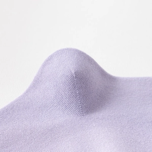 Nahaufnahme der nahtlosen Fersennaht an lavendelfarbenen Strickbaumwollsocken mit Textur