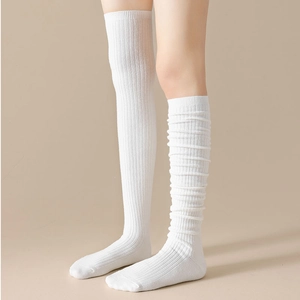 Detail of white ribbed knit over-the-knee socks showing texture and slouchy style