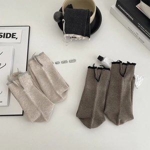 Detailed macro view of three pairs of vintage ribbed socks with split heel and bow detail