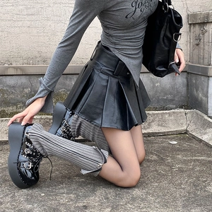 Close-up of gray knitted leg warmers featuring a metal side zipper for a street style look
