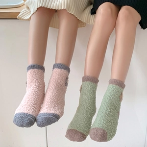 Detail of coral fleece thick socks with cute cartoon animal decorations and soft texture