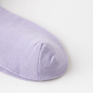 Makroansicht der nahtlosen Fußspitze lila gestrickter Baumwollsocken für Damen