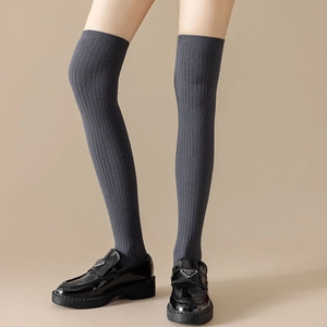Detailed knit texture of dark grey over-knee socks with vertical striped patterns