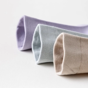 Makroaufnahme weicher Rippstrick-Baumwollsocken in Violett, Blau und Beige