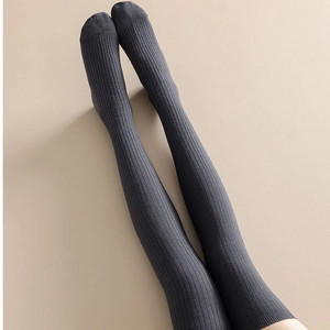 Detail shot of dark gray vertical striped knit over-knee socks with slimming texture