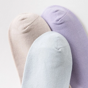 Detail von weichen Baumwollsocken in Pastelllila, Blau und Beige mit Zehennaht-Ansicht