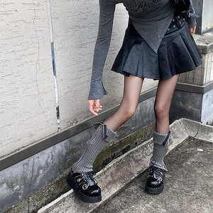 Detail of grey knitted leg warmers with side zipper paired with black gothic platform shoes