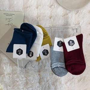 Five pairs of minimalist cotton crew socks in navy, beige, yellow, grey and burgundy colors