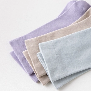 Nahaufnahme der gerippten Strickstruktur der Baumwollsocken in Pastelllila, Beige und Blau