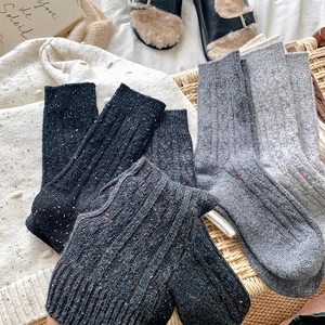 Close-up of thick cable knit tweed socks with colorful specks in assorted grey tones