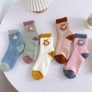 Detailed view of five pairs of warm coral fleece bear socks in various color combinations