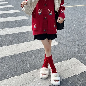 Détail de jambières rouges en tricot côtelé avec motif renne et sandales à plateforme
