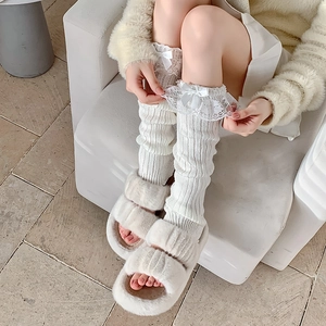 Detail von weißen Lolita Beinstulpen mit feiner Spitze und Satin-Schleifen-Akzenten