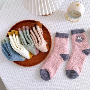 Detailed texture of thick coral fleece winter socks with cute cartoon bear embroidery