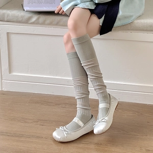 Chaussettes mi-bas gris clair en maille côtelée avec ballerines blanches sur bois
