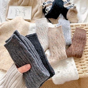 Close-up of thick cable knit texture and colorful tweed dots on warm winter crew socks