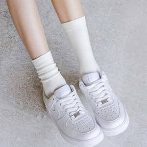 Minimalistische weiße Strick-Mittelsocken kombiniert mit weißen Leder-Sneakern