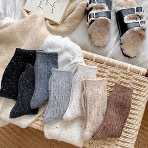 Detailed view of speckled cable knit wool socks in neutral tones for winter warmth