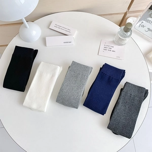 Flat lay of five classic knit knee-high socks in neutral tones with ribbed texture detail