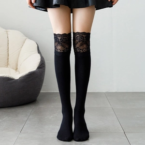 Detail of black over-knee socks featuring elegant lace trim and fine knit texture