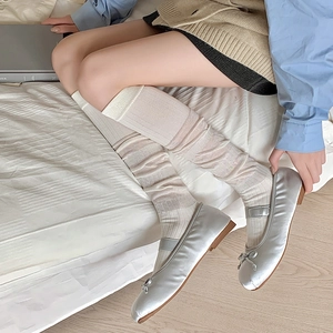 Détail de chaussettes hautes blanc crème avec chaussures Mary Jane argentées style ballet