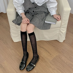 Detailed close-up of breathable black semi-sheer calf socks with wide elastic cuffs
