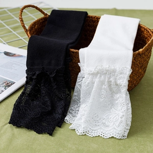 Detailed close-up of sweet Lolita knee-high socks with floral lace trim in black and white