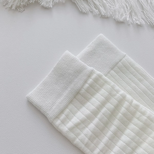 Macro shot of white ribbed knit fabric texture and elastic cuffs on mid-calf socks