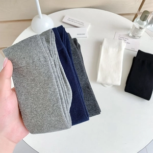 Detailed macro view of soft ribbed cotton calf socks in various minimalist solid colors