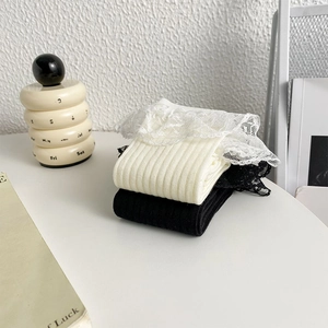 Détail de chaussettes en maille avec bordure en dentelle en noir et blanc crème