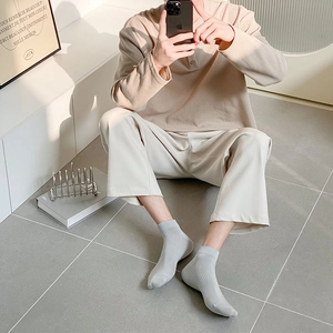 Close-up of light grey ribbed cotton socks worn with waffle knit top and casual pants