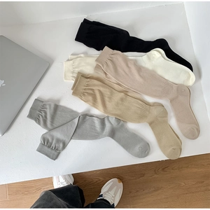 Texture detail of five pairs of ribbed cotton knee-high socks in various neutral tones