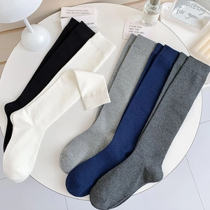 Flat lay of five-color cotton knee-high socks set including black, white, and grey tones