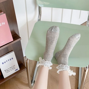 Detailed view of grey ribbed mid-calf socks with delicate white lace trim and bow accent