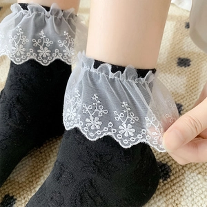 Detailed close-up of black lace socks featuring white floral embroidery and frill edge