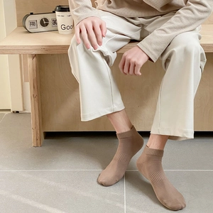 Detail of khaki cotton sports socks featuring ribbed cuffs and non-slip arch support