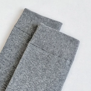 Close-up of ribbed cuffs on gray knit knee-high socks showing textured cotton blend fabric