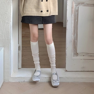 Gros plan de chaussettes hautes blanches à côtes avec des ballerines argentées chic