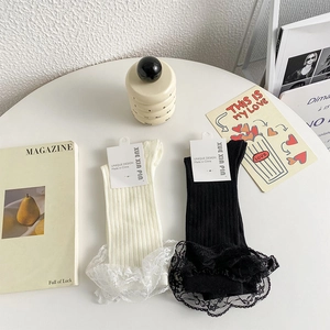 Détail de chaussettes montantes à fines côtes et bordure en dentelle élégante