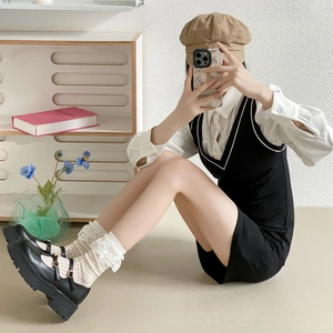 Détail de chaussettes blanches à dentelle Lolita portées avec des chaussures Mary Jane