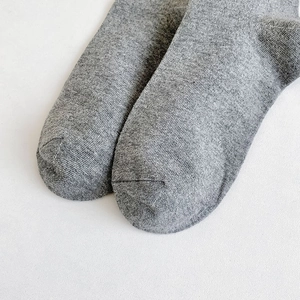 Detailed close-up showing the seamless toe stitching of grey cotton knee-high socks