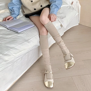 Détail de chaussettes hautes côtelées beige clair et chaussures Mary Jane