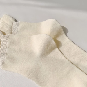 Détail de chaussettes mi-mollet blanc crème montrant le talon renforcé et la maille fine