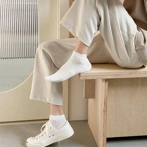 Close-up of white cotton ankle socks with elastic ribbing and anti-slip arch support texture
