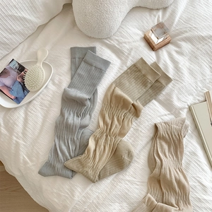 Détails de trois paires de chaussettes hautes en tricot côtelé gris et beige