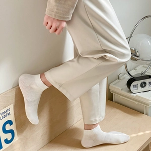 Close-up of white cotton ankle socks with elastic ribbed cuffs on a model for casual wear