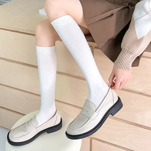 Japanese style white ribbed knee high socks paired with platform loafers for women