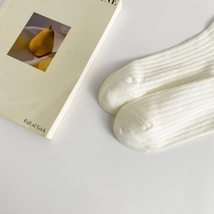 Détail de chaussettes blanches côtelées avec de fines rayures verticales style Lolita